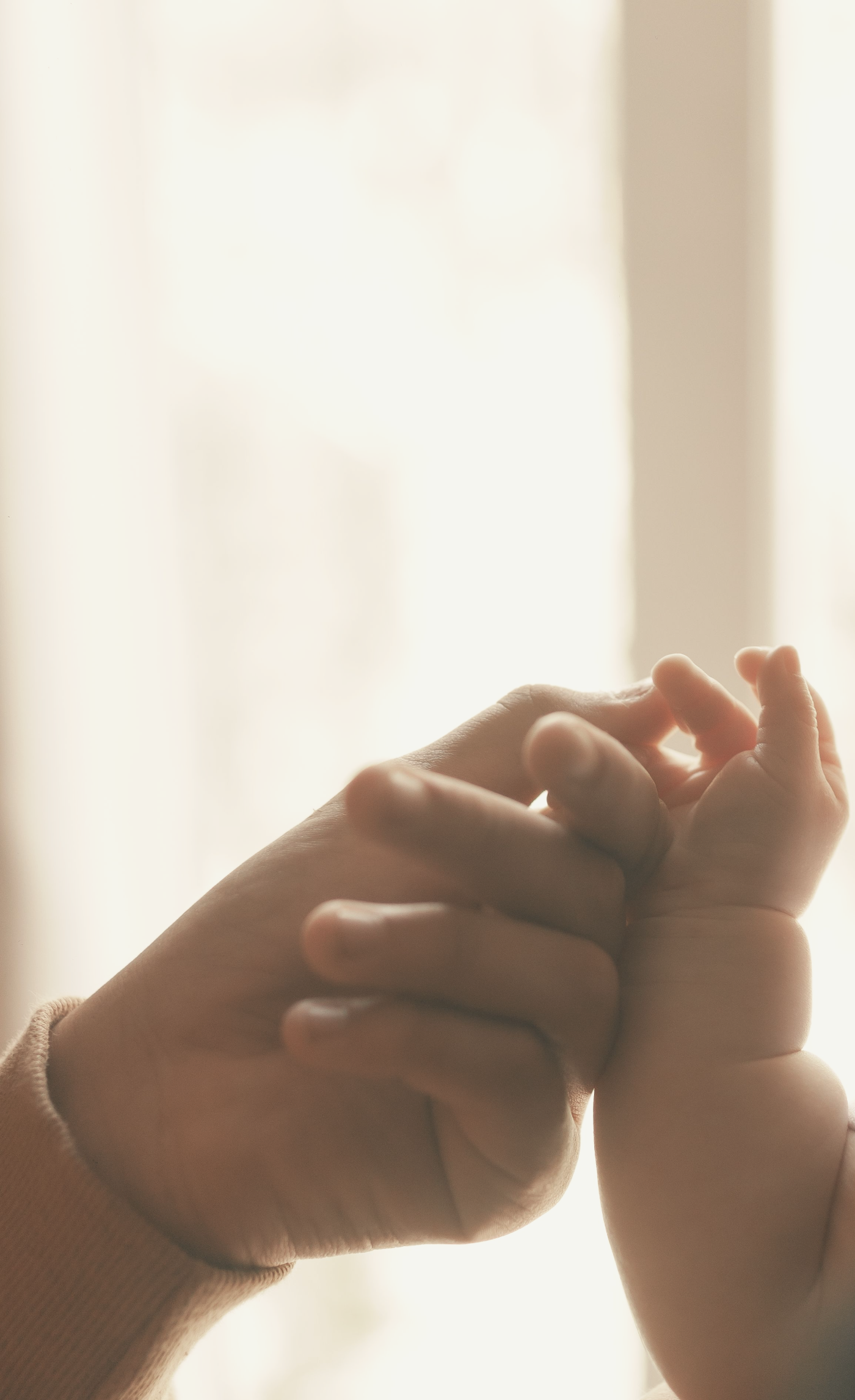 Hand van een ouder om de hand van een baby